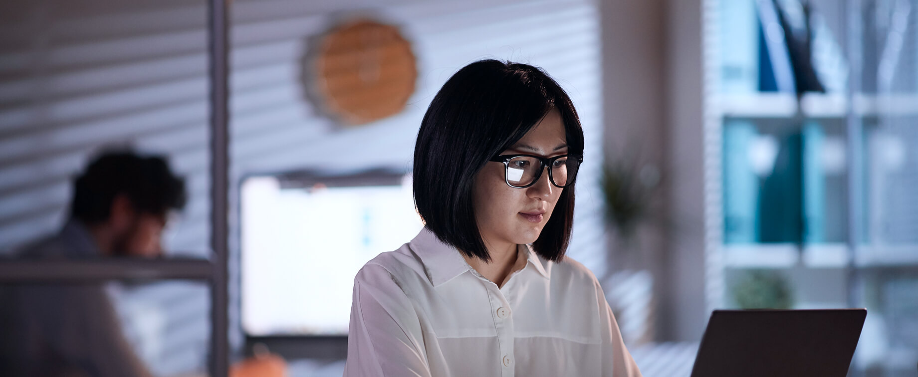 1人の女性がオフィスでノートPCを操作している写真